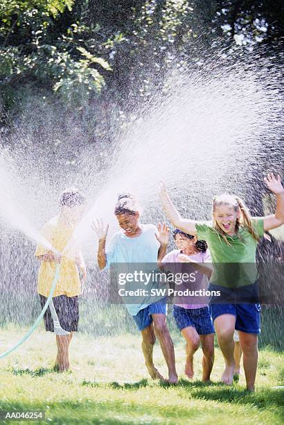 children playing with water sprinkler - somente crianças - fotografias e filmes do acervo