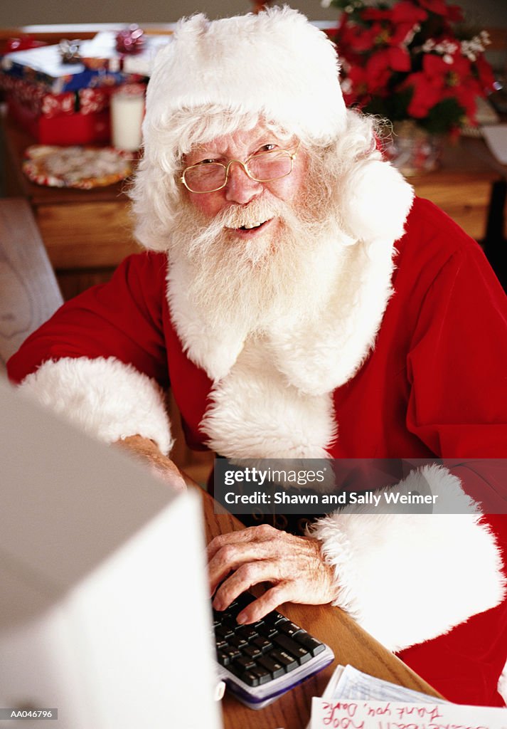 Santa Claus at using computer, smiling, portrait