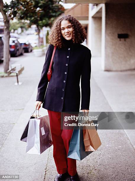 young woman carrying shopping bags - donna elegante stock-fotos und bilder