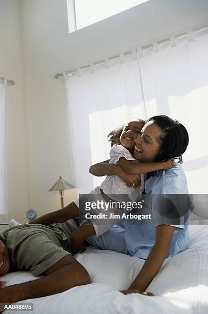 family in bedroom, girl (2-4) hugging mother - カーテンレール ストックフォトと画像