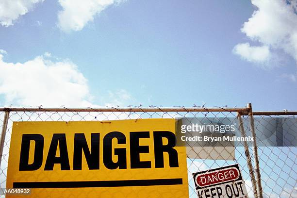 danger sign on fence, low angle view - restricted area sign stock-fotos und bilder