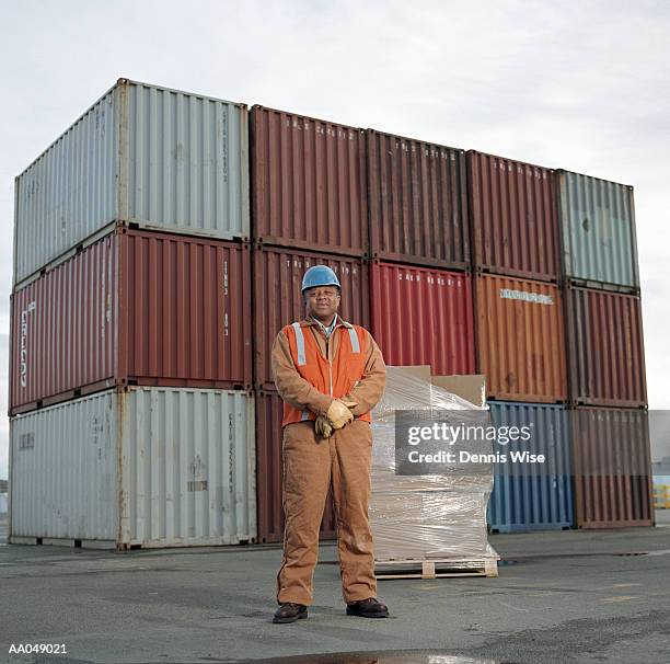 male worker standing in front of cargo containers, portrait - black jumpsuit stock pictures, royalty-free photos & images