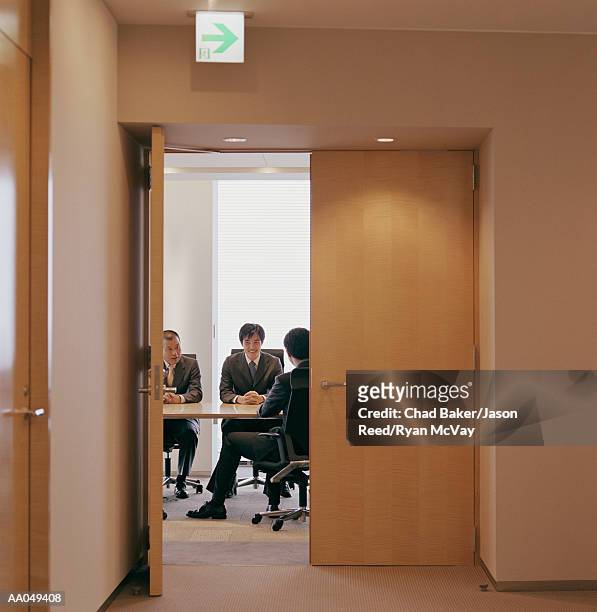 businessmen meeting in conference room, view through double-doors - japanese exit sign stock pictures, royalty-free photos & images