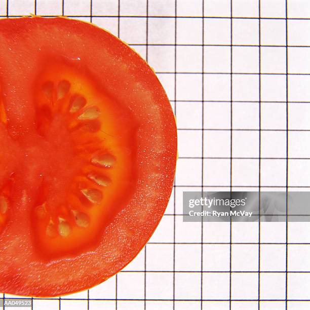 tomato slice on graph paper - alimento genéticamente modificado fotografías e imágenes de stock