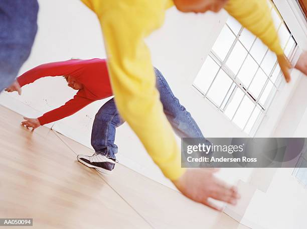 two boys (6-8) doing cartwheels in room - boy cartwheel stock pictures, royalty-free photos & images
