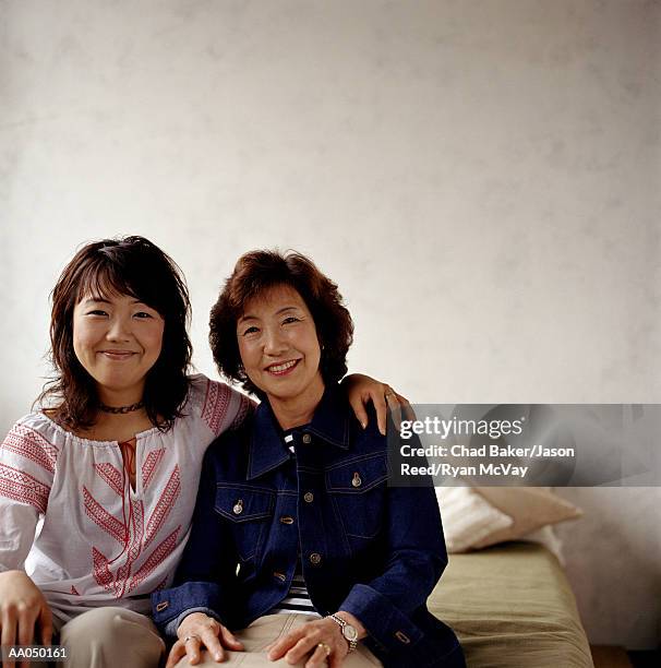 young woman sitting with mature mother on bed, portrait - reed bed stock pictures, royalty-free photos & images