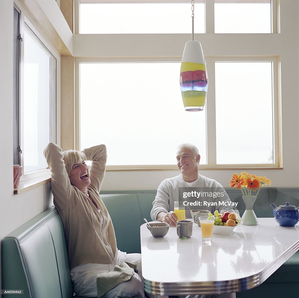 Mature couple laughing over breakfast