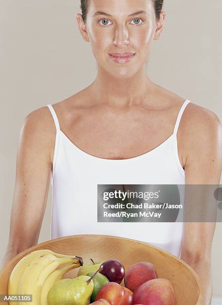 young woman holding bowl of fruit, portrait - limes top stock pictures, royalty-free photos & images