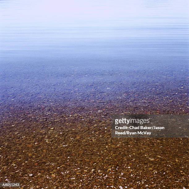 rocks in shallow surf on beach - baker beach stock pictures, royalty-free photos & images