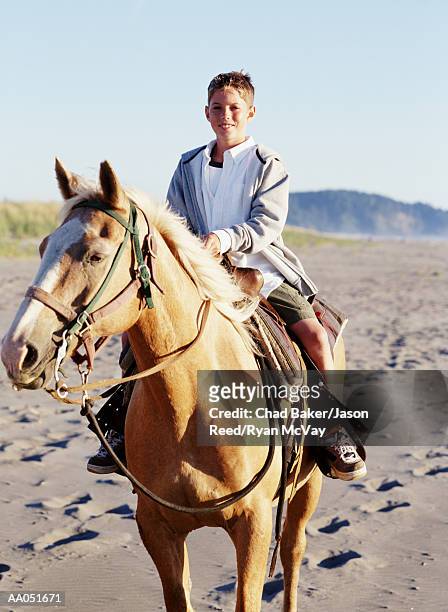 boy (9-11) riding horse on beach, washington, usa (selective focus) - baker beach stock pictures, royalty-free photos & images