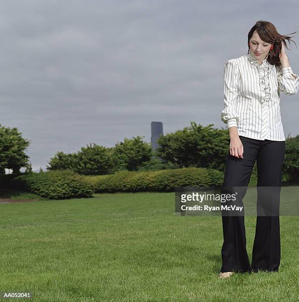 young woman standing barefoot in field, looking down - down blouse stock pictures, royalty-free photos & images