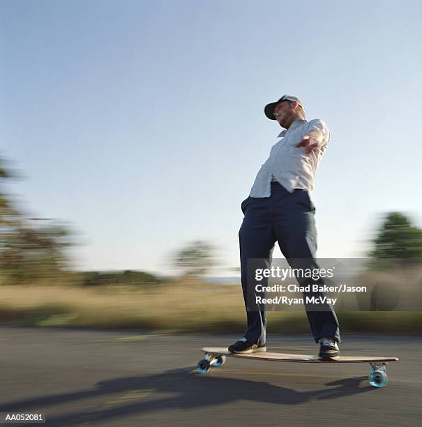 young man skating on longboard, side view (blurred motion) - surfista de asfalto imagens e fotografias de stock