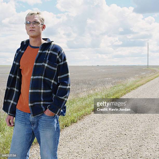young man walking on dirt road, drumheller, canada - drumheller stock pictures, royalty-free photos & images