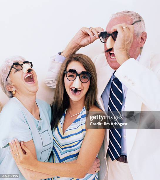 teenage girl (14-16) and grandparents wearing disguise glasses - groucho marx disguise stock pictures, royalty-free photos & images