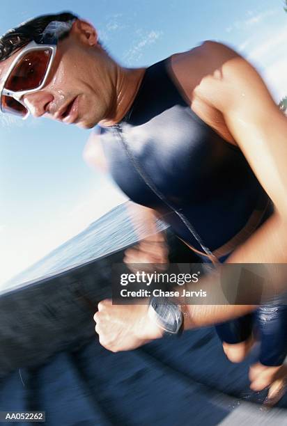triathlete wearing swimwear, exiting water (blurred motion) - jarvis summers stock pictures, royalty-free photos & images