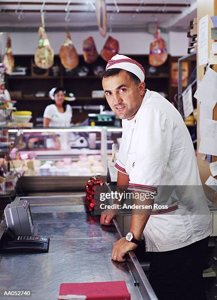 man working behind counter in delicatessen, italy (selective focus) - butcher portrait stock-fotos und bilder