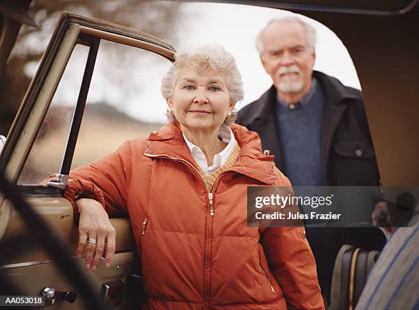 mature man and woman getting into vehicle (selective focus) - passagerarsäte bildbanksfoton och bilder