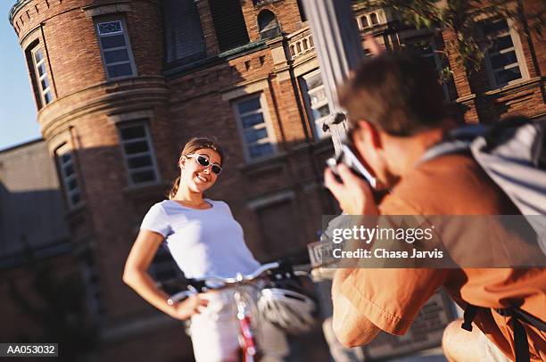 man taking picture of young woman standing on sidewalk with bicycle - verwaltungsbezirk pierce county stock-fotos und bilder