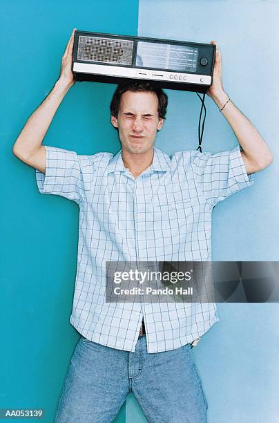 man lifting old radio above head - portable radio stock pictures, royalty-free photos & images