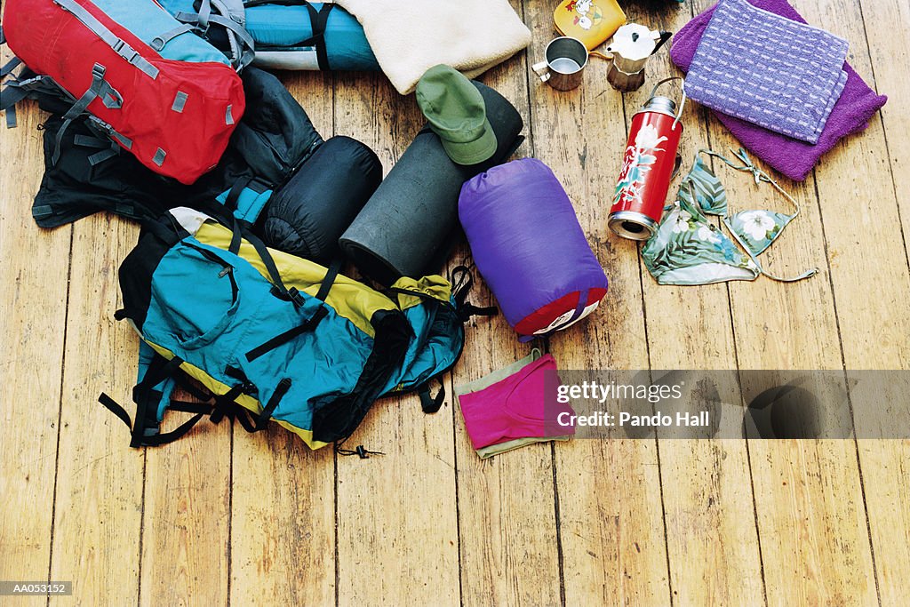 Camping gear scattered on wood floor, elevated view