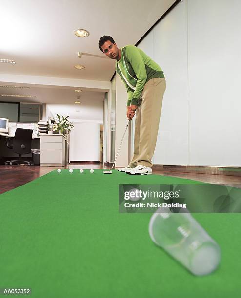 young executive playing golf in office (blurred motion) - bent golf club stock pictures, royalty-free photos & images