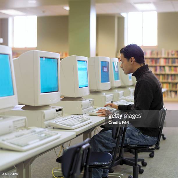 teenage boy (16-18) using computer, high school library, side view - f 16 stock pictures, royalty-free photos & images