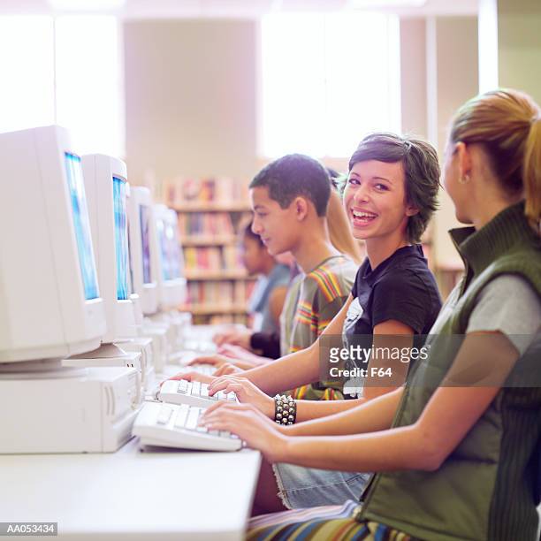 group of high school students using computers in school library - f 16 stock pictures, royalty-free photos & images