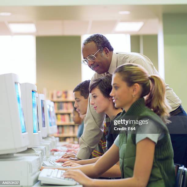 high school students using computers, library, teacher assisting - f 16 stock pictures, royalty-free photos & images