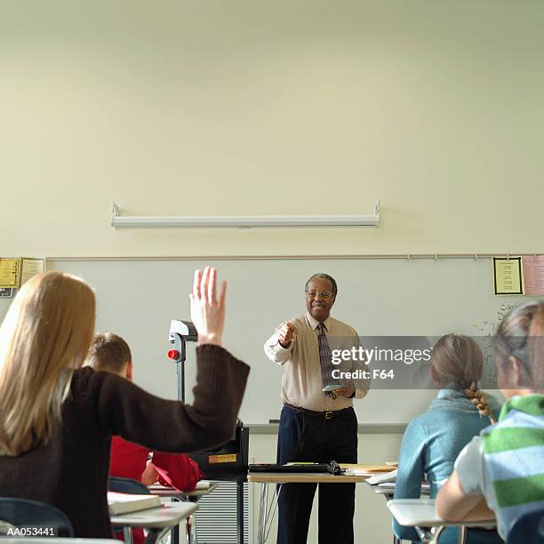 high school teacher calling on student, view from back of classroom - f 16 stock pictures, royalty-free photos & images