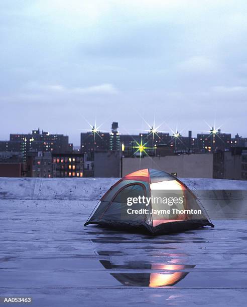 tent illuminated on urban rooftop, twilight - style du xxième siècle photos et images de collection