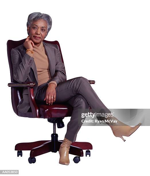 mature businesswoman sitting in office chair - only mature women stock pictures, royalty-free photos & images