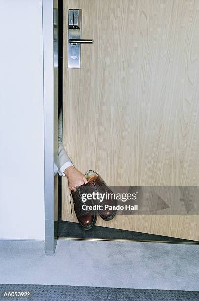 businessman setting shoes outside hotel room door, close-up of shoes - pando stock pictures, royalty-free photos & images