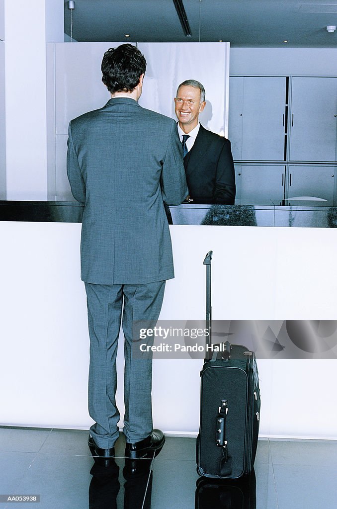 Businessman standing at hotel reception desk