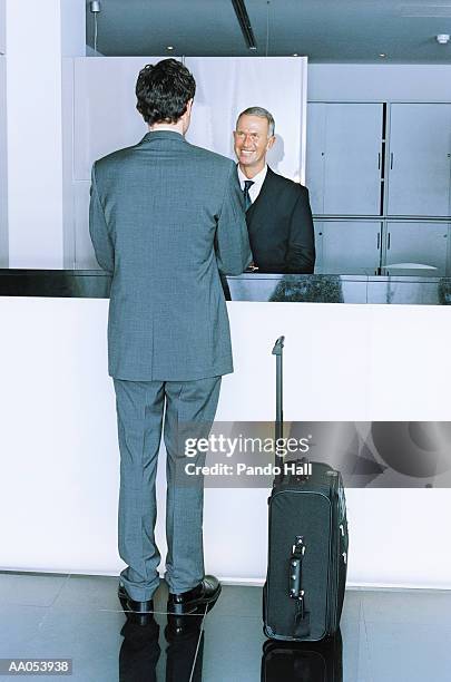businessman standing at hotel reception desk - estroboscópio circular imagens e fotografias de stock