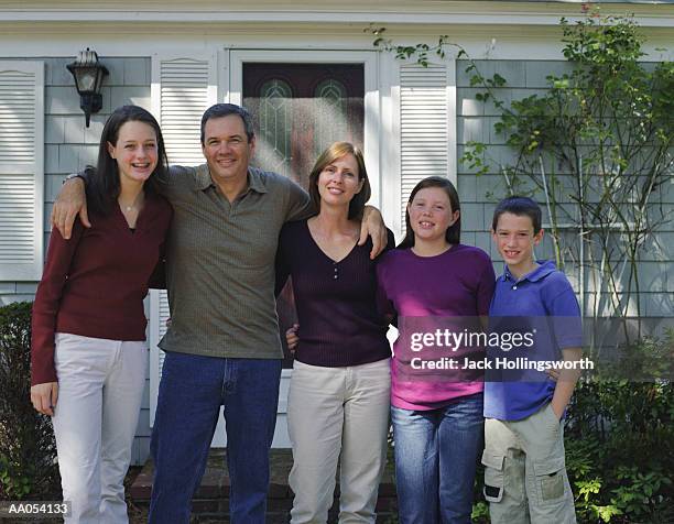 family standing on front steps of house, portrait - portrait of young woman standing against steps imagens e fotografias de stock