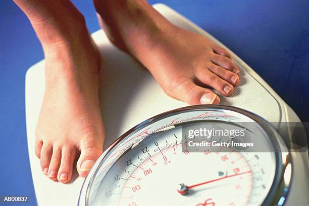 woman's feet on a bathroom scale - bathroom scales stock pictures, royalty-free photos & images