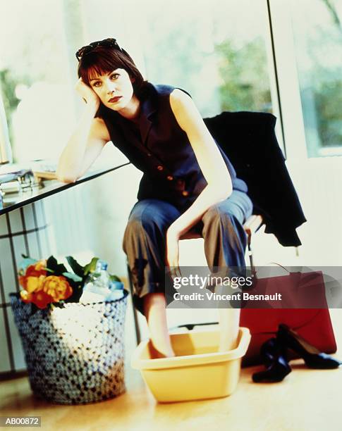 businesswoman soaking feet in basin at home - basin ストックフォトと画像