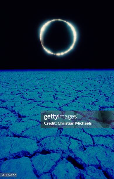 solar eclipse above dry lake bed (composite) - eclipse foto e immagini stock