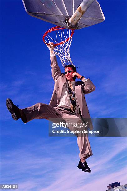businessman usin mobile phone, hanging from basketball net - suits hanging stock pictures, royalty-free photos & images