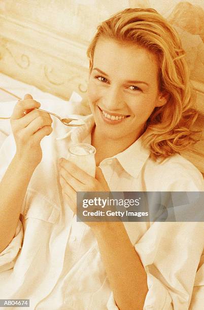 woman eating yogurt - yoghurt pot stock pictures, royalty-free photos & images