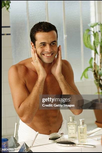 man putting on aftershave - man aftershave stock pictures, royalty-free photos & images