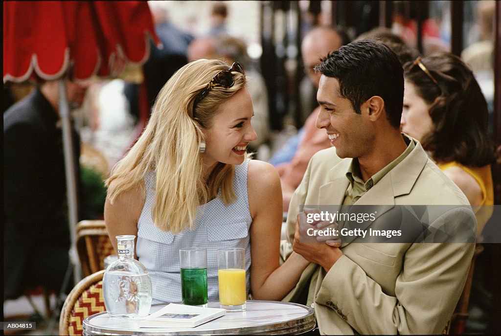 Couple holding hands at table in cafe