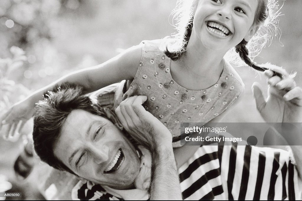 Father lifting daughter over shoulder (B&W)