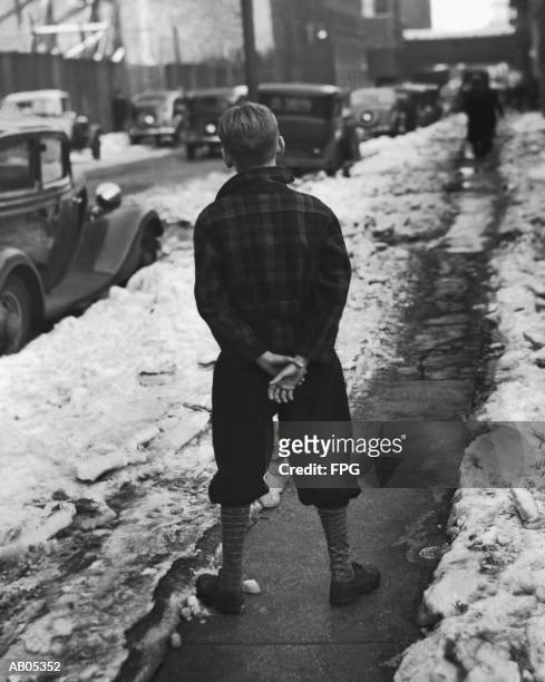 boy standing on sidewalk - pantalones de media pierna fotografías e imágenes de stock