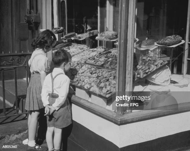 boy and girl looking in at bakery window / archive shot - bakery window stock pictures, royalty-free photos & images