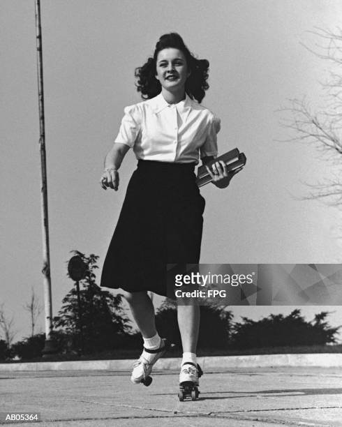 teenage girl roller skating to college, carrying books / 1950's - 1950s roller skates stock pictures, royalty-free photos & images