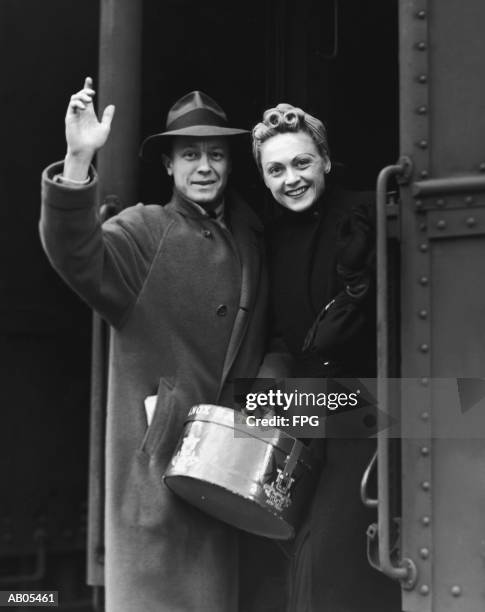 couple waving as they board a train / circa 1930's - caixa de chapéu imagens e fotografias de stock