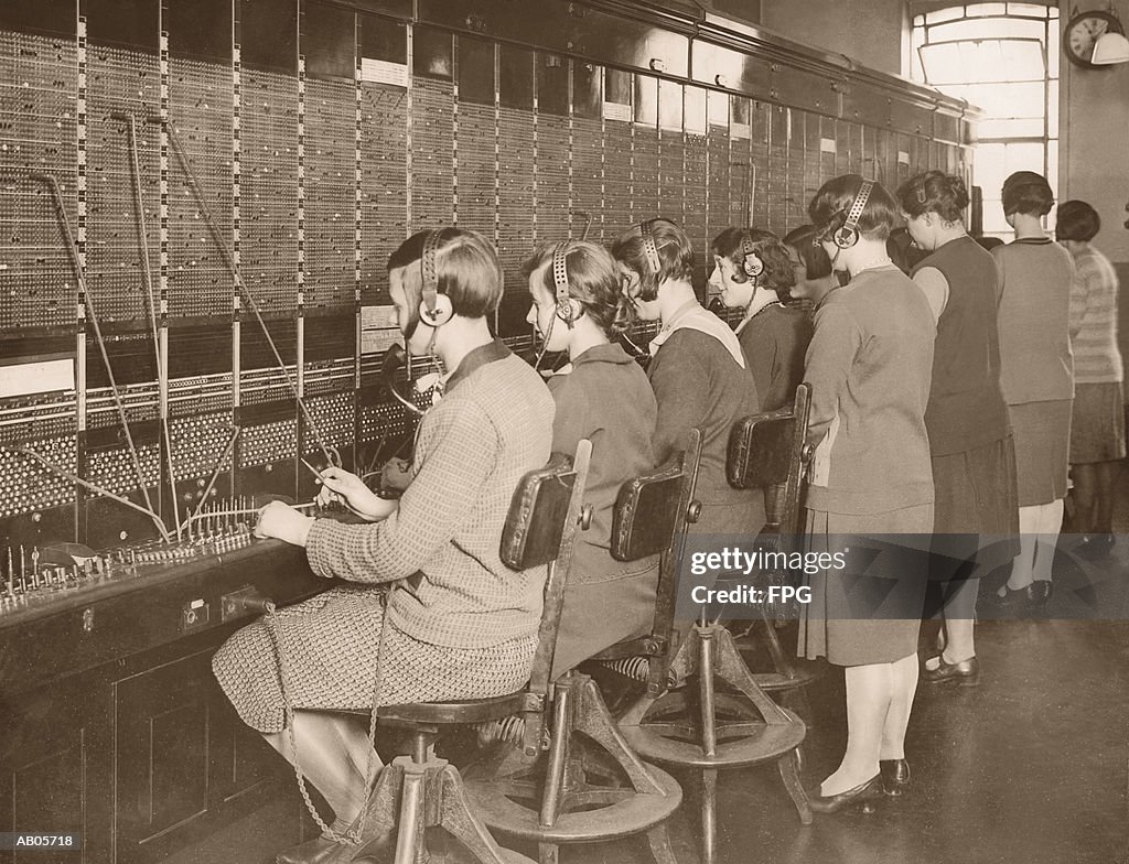 Female telephone switchboard operators training, rear view (B&W)