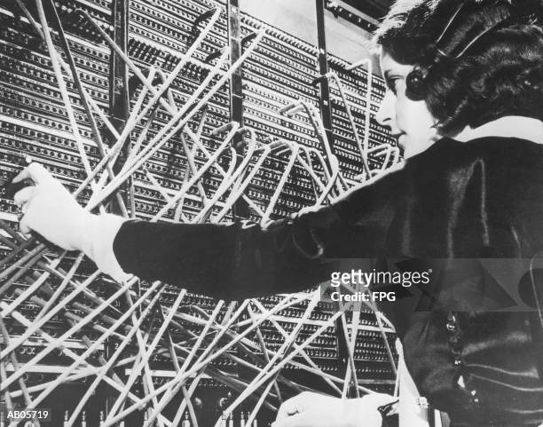 female telephone switchboard operator connecting caller, close-up (b&w - telephone switchboard stock pictures, royalty-free photos & images