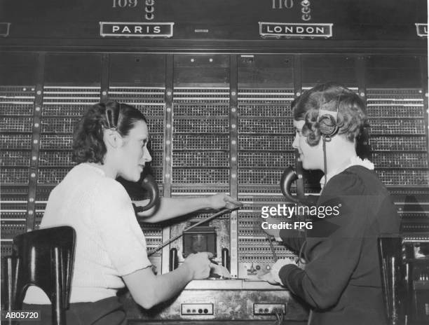 two female switchboard operators connecting international calls (b&w) - switchboard operator stock pictures, royalty-free photos & images